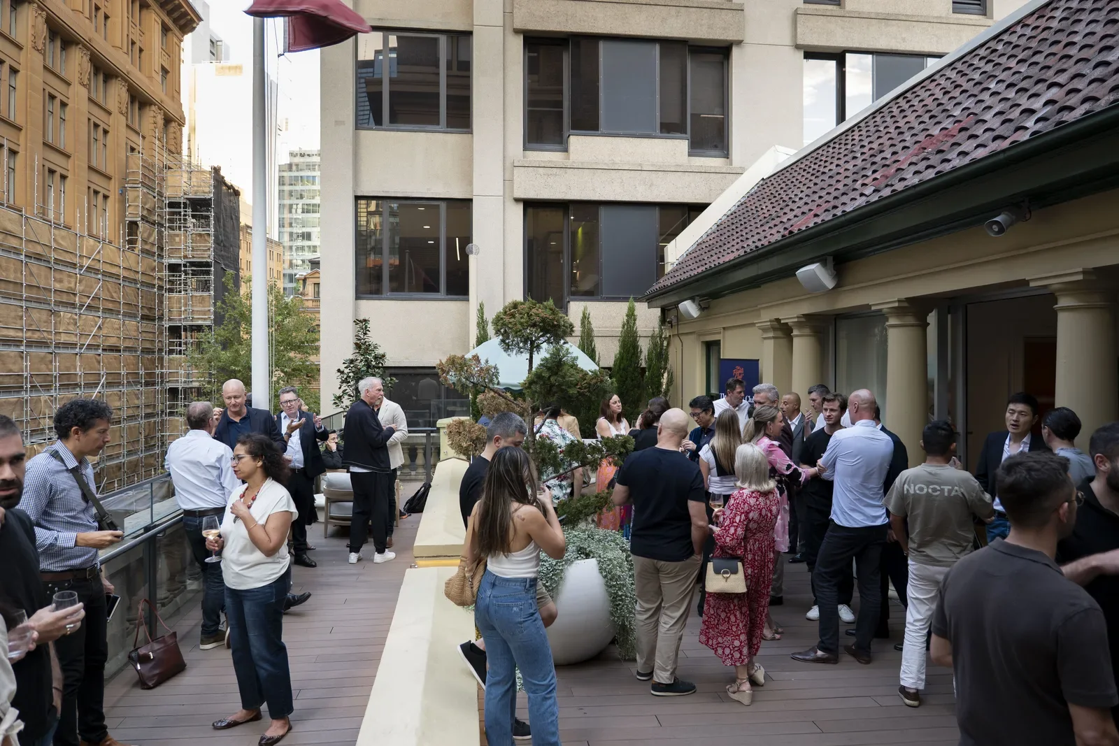Flights Club guests talking at an outdoor rooftop gathering